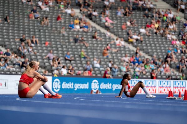 Jara Ellinger (TSG 1845 Heilbronn) und Blessing Enatoh (TSV Spandau 1860) sitzen auf der Bahn waehrend der deutschen Leichtathletik-Meisterschaften im Olympiastadion am 25.06.2022 in Berlin